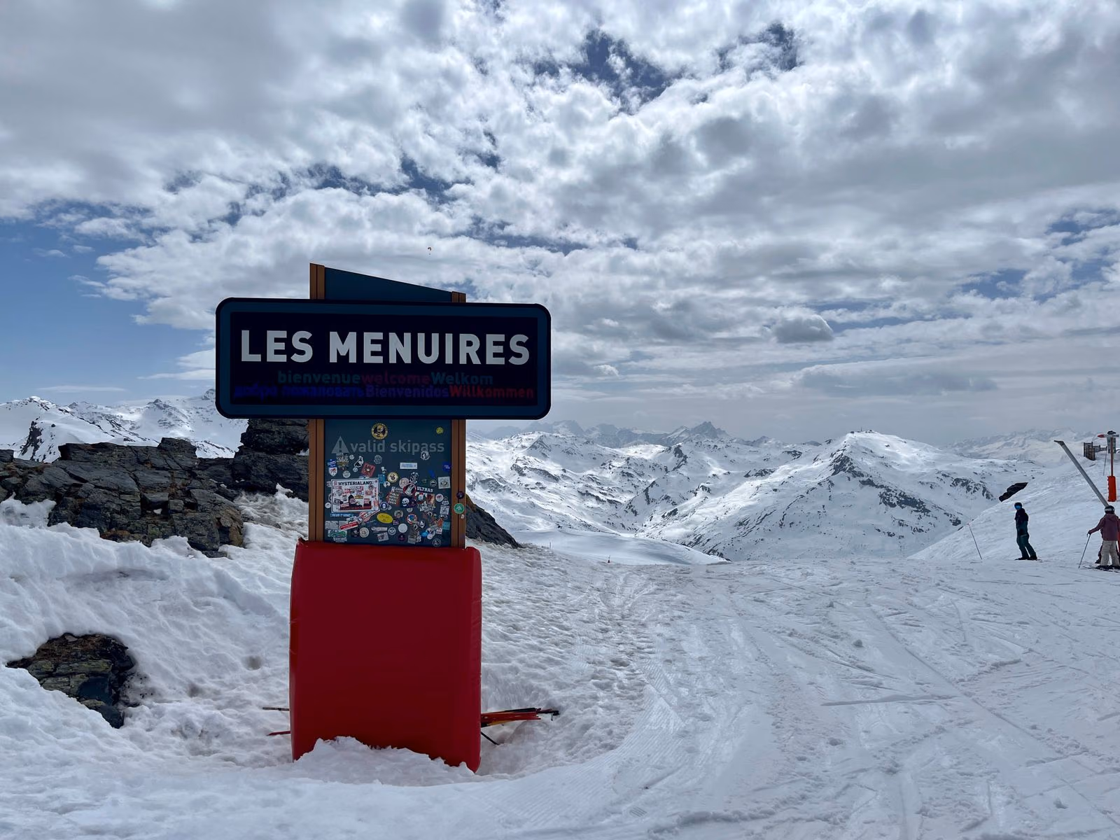 Immeubles de style chalet dorés par le soleil rasant sur une pente enneigée aux Menuires.